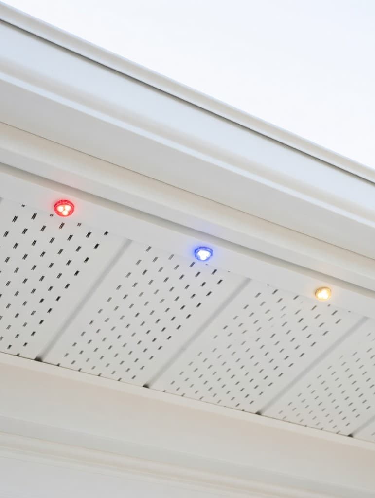 White colour matched hat track along fascia and perforated soffit with recessed LED nodes on a residential roofline