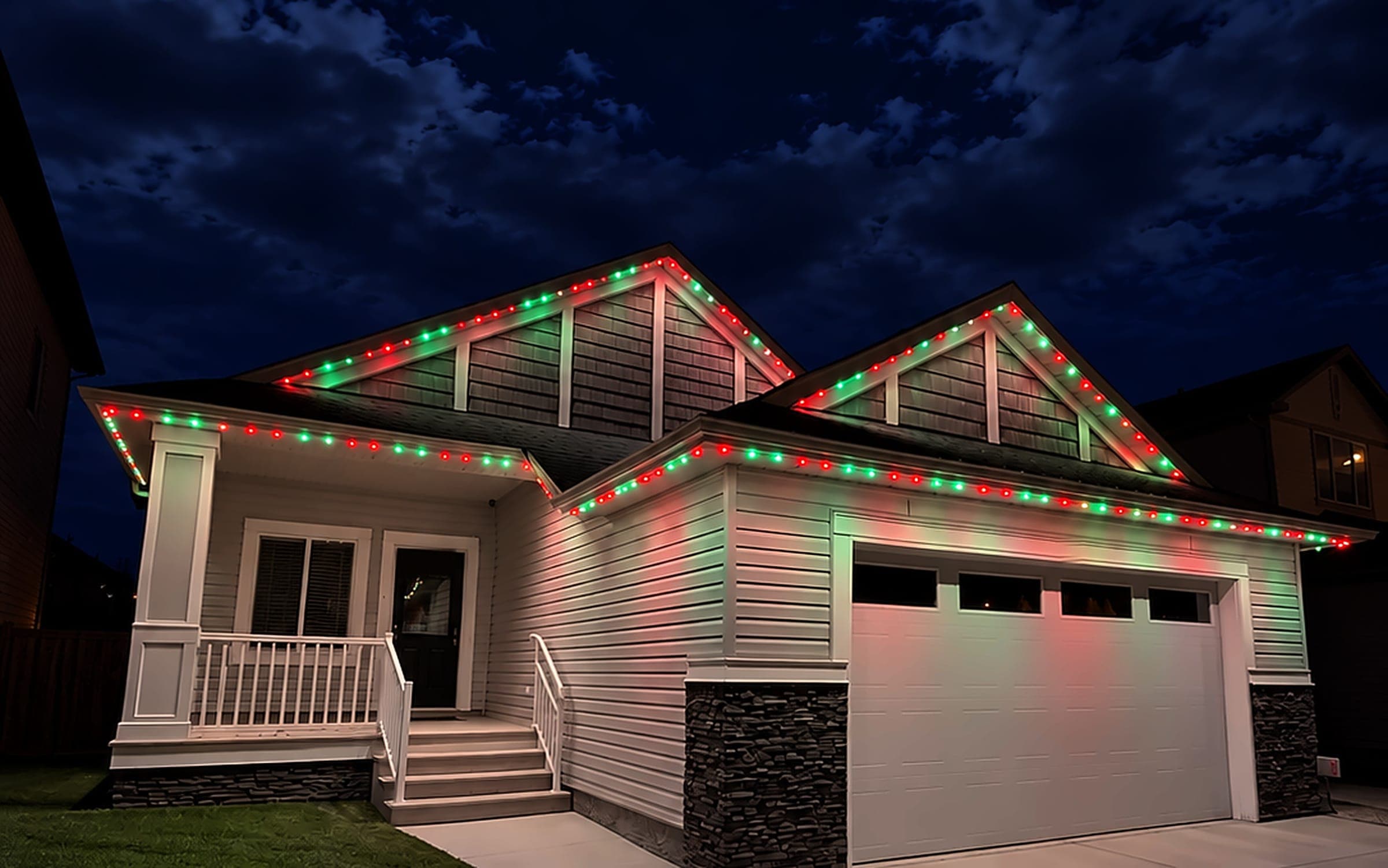 Home lit red and green for Christmas with permanent roofline lights