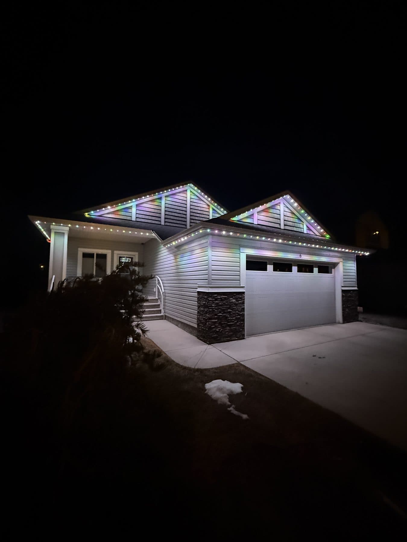 Permanent LED lights showing a soft pastel gradient scene across a home roofline and gables