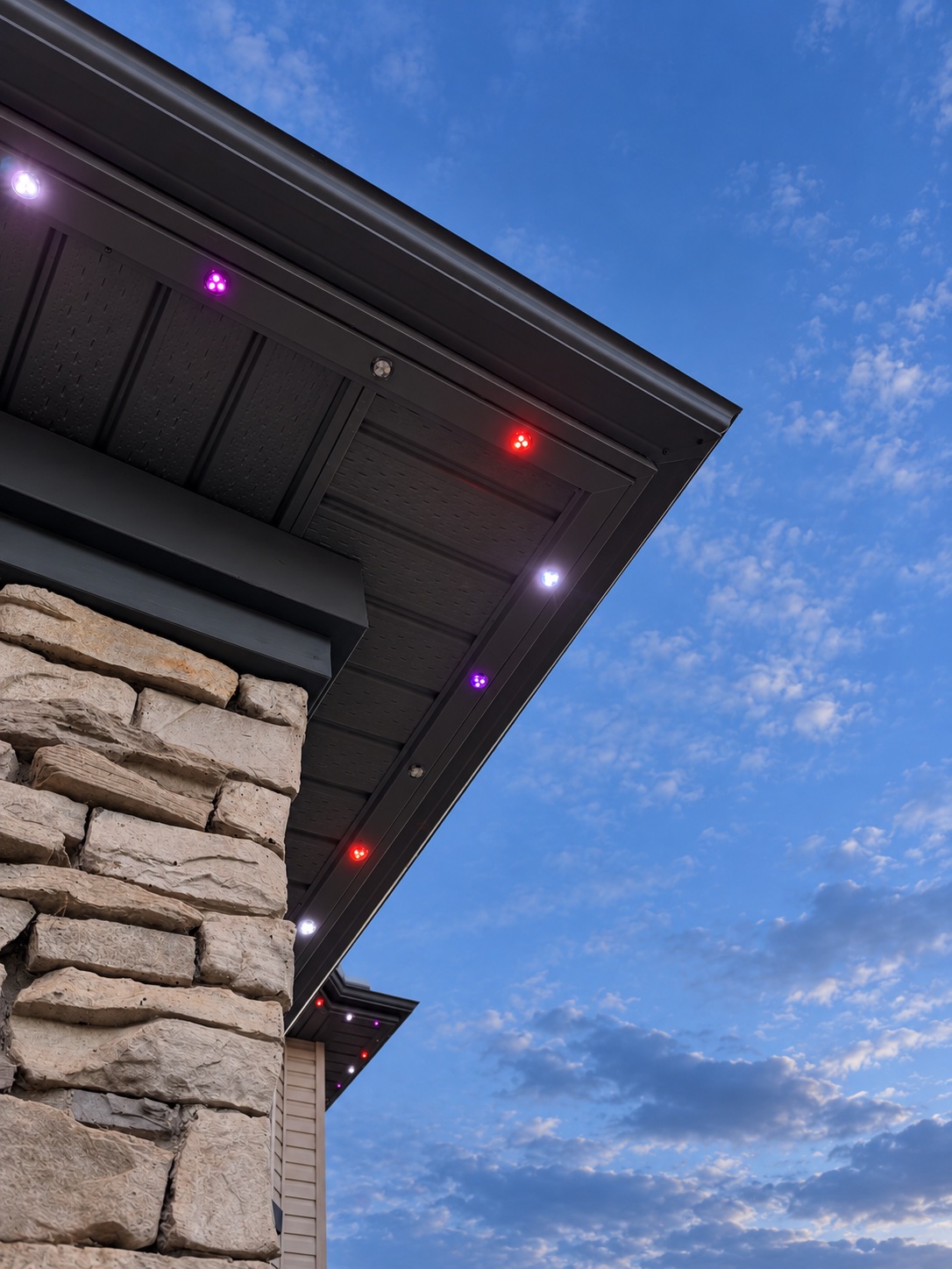 Close-up of colour LED pucks glowing under the eave