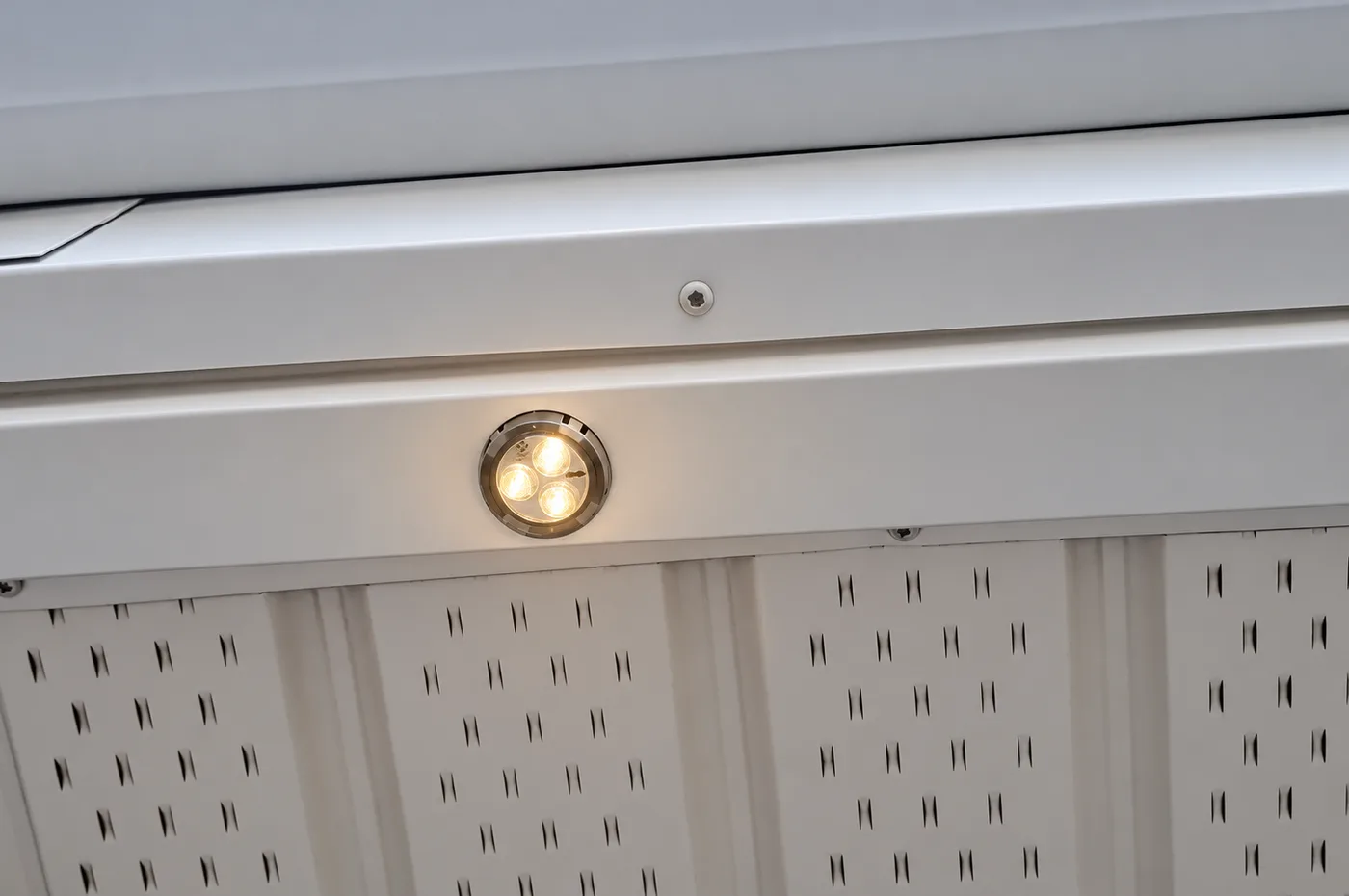 Close-up of a permanent LED puck light set into a white soffit